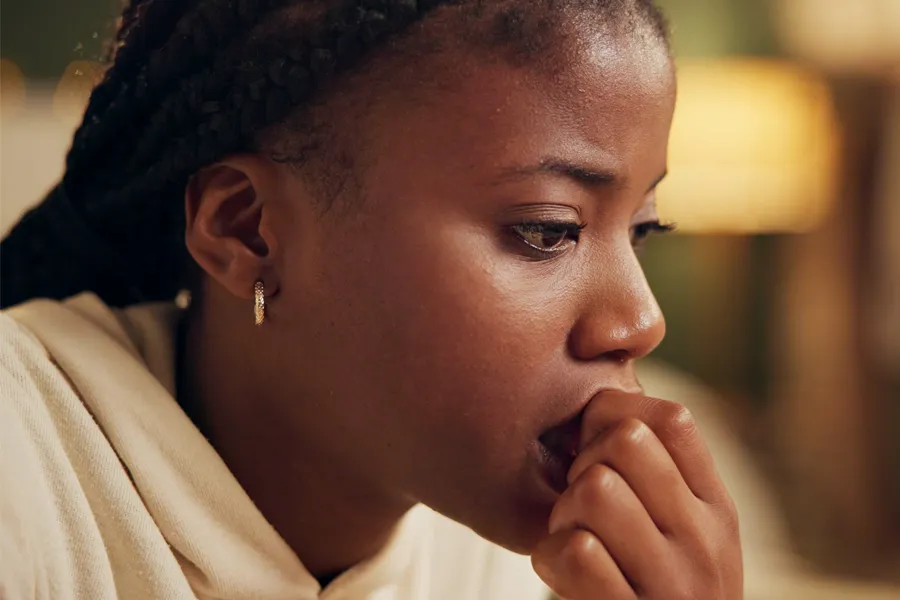 Anxiety-Clinic A black woman bites her nails with worry. Get treatment for anxiety from Dr. Donna Diamond in Louisville/Boulder.