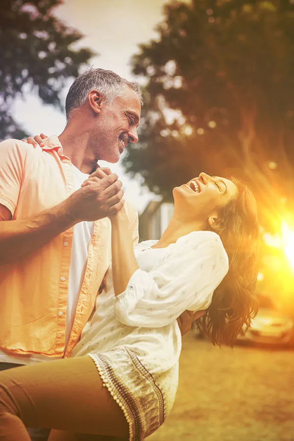 Back-Pain-Treatment A middle-aged couple dance in their yard at sunset. Get Osteopathic Manipulative Treatment for back pain from Dr. Donna Diamond in Louisville/Boulder.