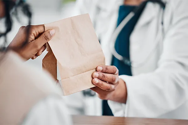 Compounding-Medicine-Clinic A clinician hands a patient a bag of compounded medicine. Schedule compounding medicine treatment from Dr. Donna Diamond in Louisville/Boulder.