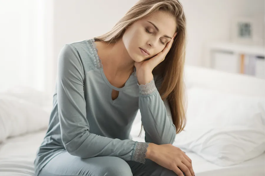 Depression-Clinic A woman sits on the edge of her bed with her head in her hands. Schedule treatment for depression from Dr. Donna Diamond in Louisville/Boulder.