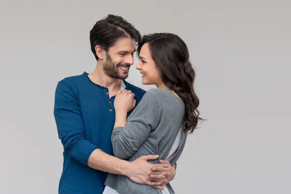 Erectile-Dysfunction-Doctor A man in a blue shirt embracing a woman in a gray shirt smiles due to his successful erectile dysfunction care from Dr. Donna Diamond in Louisville/Boulder.