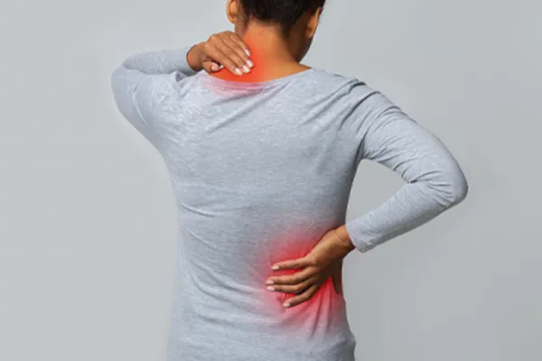 Fibromyalgia-Clinic An image from behind of a woman suffering from Fibromyalgia holding her hands on her neck and lower back. Get fibromyalgia care from Dr. Donna Diamond in Louisville/Boulder.