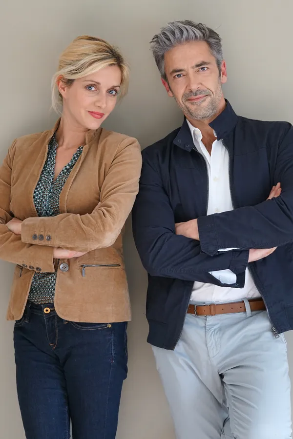 Hyperthyroidism-Treatment A middle-aged couple stand against a wall smiling with folded arms. Get hyperthyroidism treatment from Dr. Donna Diamond in Louisville/Boulder.