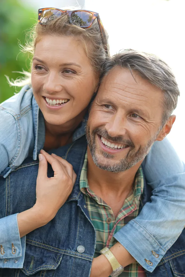 Hypogonadism-Treatment A couple in denim jackets embrace playfully outdoors. Get hypogonadism treatment from Dr. Donna Diamond in Louisville/Boulder.