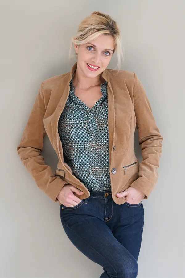 Metabolic-Syndrome-Treatment A smiling blonde woman in a tan leather jacket leans against a gray wall. Schedule metabolic syndrome from Dr. Donna Diamond in Louisville/Boulder.