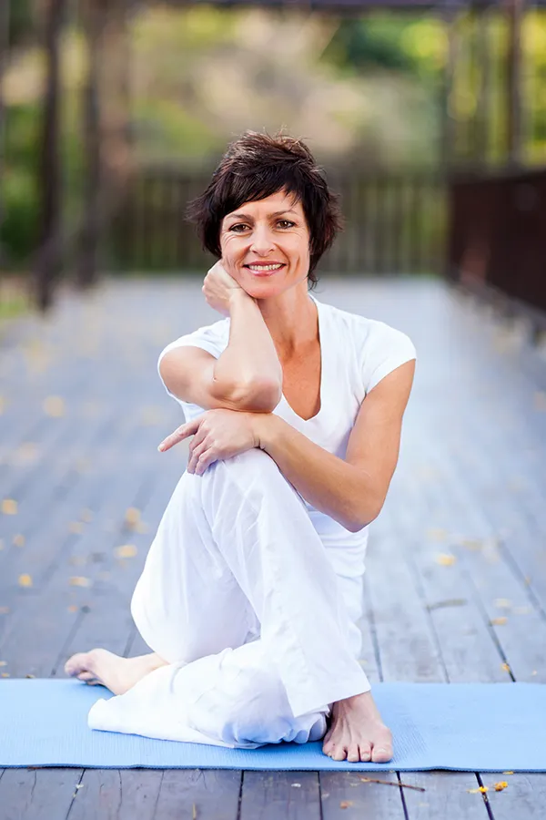 Osteopathy-Treatment A middle-aged woman sitting comfortably in a yoga pose. Get osteopathy treatment from Dr. Donna Diamond in Louisville/Boulder.