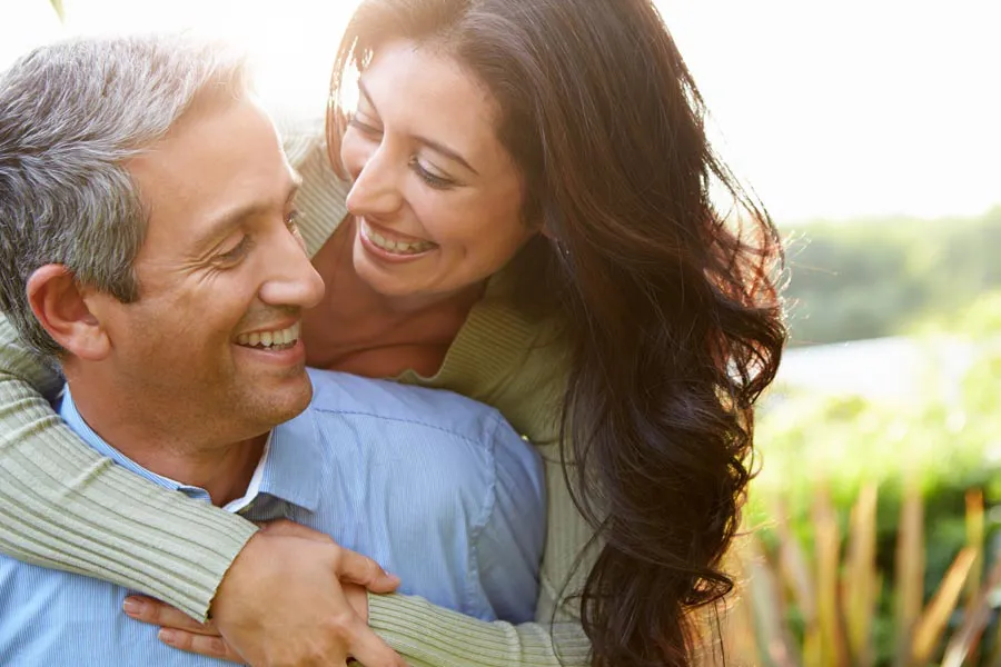 Primary-Care-Clinic A middle-aged Latin couple embrace each other in a field under the sun. Get Primary Care services from Dr. Donna Diamond in Louisville/Boulder.