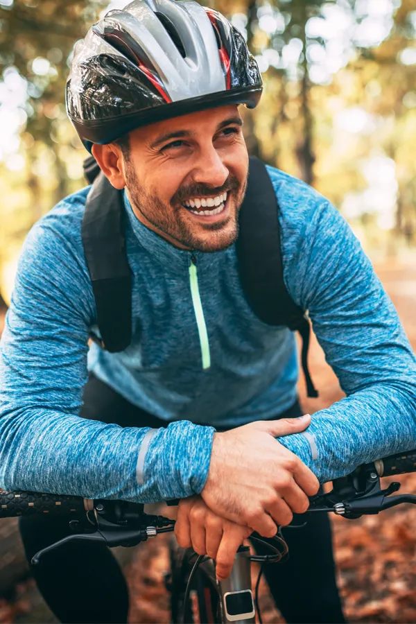 Testosterone-Low-T-Solutions-Treatment A middle-aged man on a trail in cycling clothes is smiling and leaning on his bike's handlebars. Get testosterone for Low T from Dr. Donna Diamond in Louisville/Boulder.