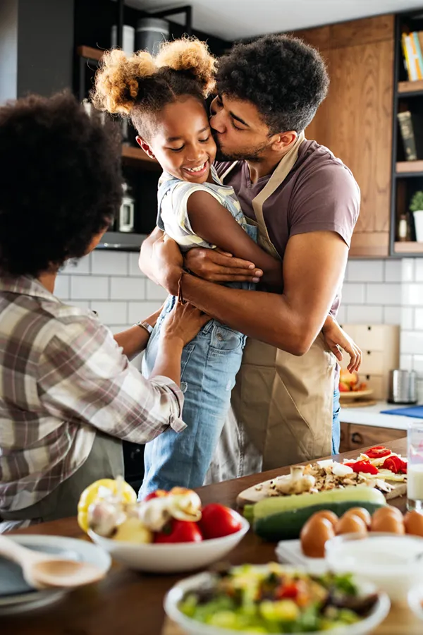 Type-2-Diabetes-Treatment Happy family of three smiling while cooking a healthy meal at home after receiving expert functional medicine for type 2 diabetes treatment by Dr. Donna Diamond in Louisville/Boulder.